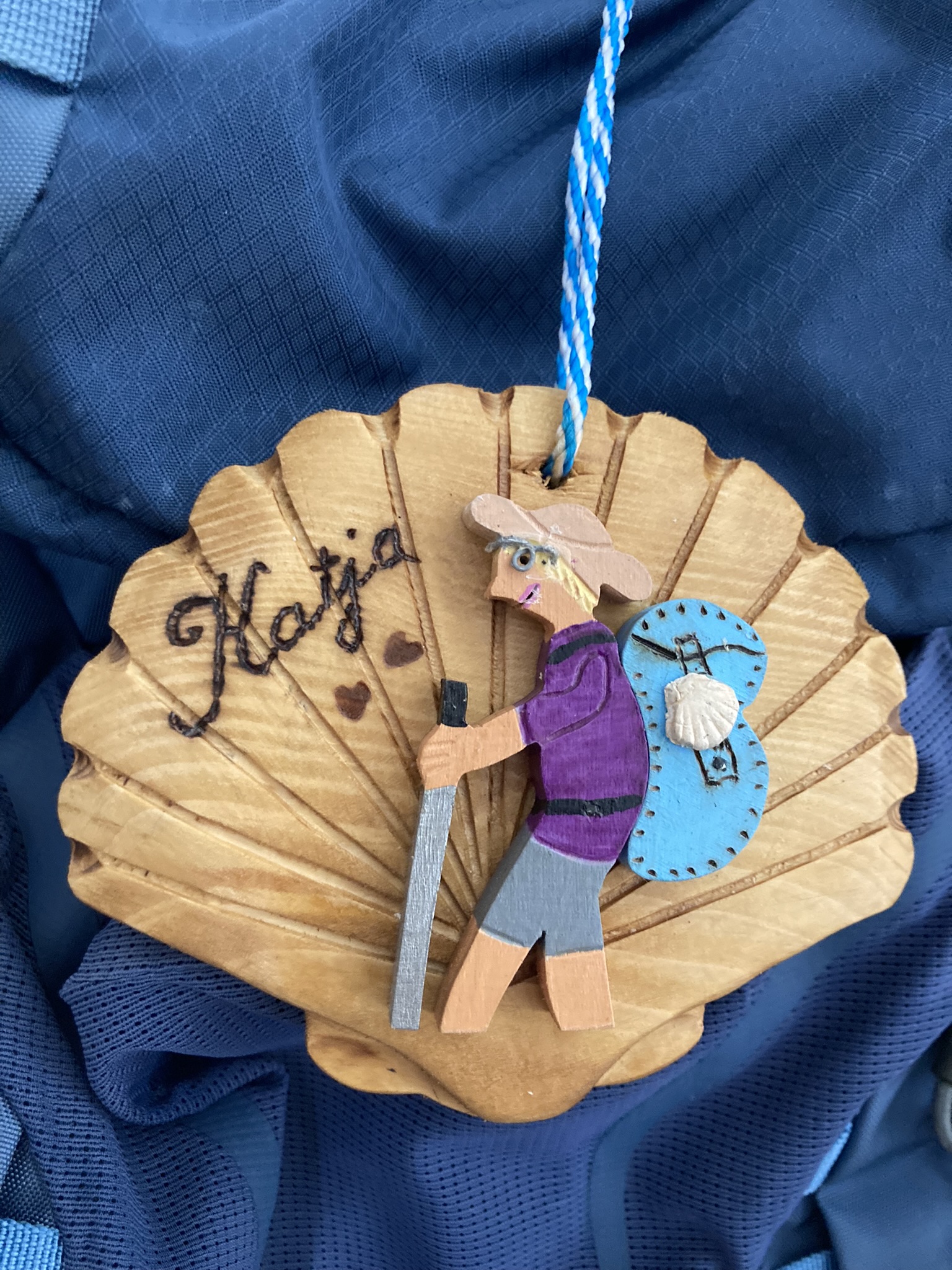 Handwerksarbeit: Aus Holz geschnitzte, personalisierte Jakobsmuschel, hergestellt von Ricou le Baroudeur.